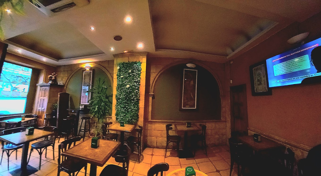 Interior real del restaurante LA ABADÍA con mesas y pantallas